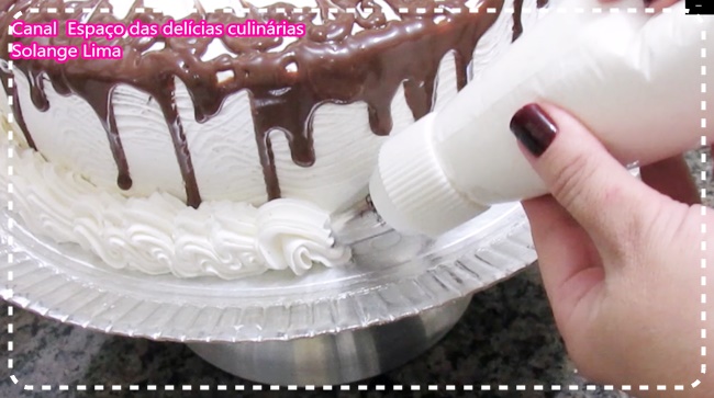 Confeitando bolo com bico, chantilly e raspas de chocolate